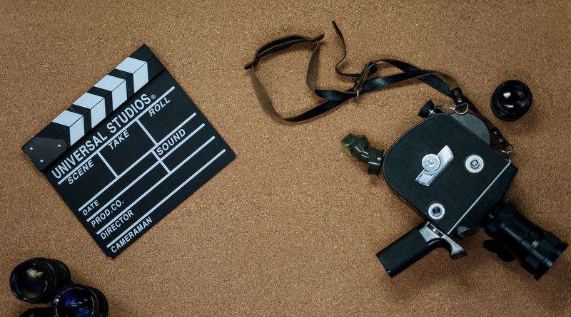 Vintage camera and clapboard on a cork board evoke a classic filmmaking vibe.